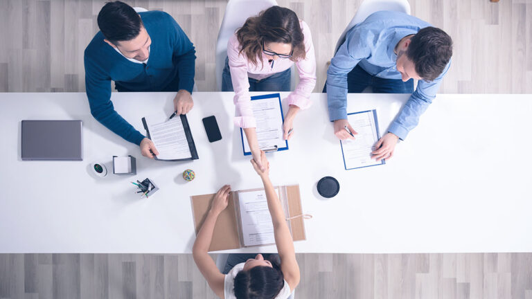 Birds eye view of people working at a desk.