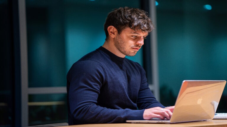 Man typing on his laptop.