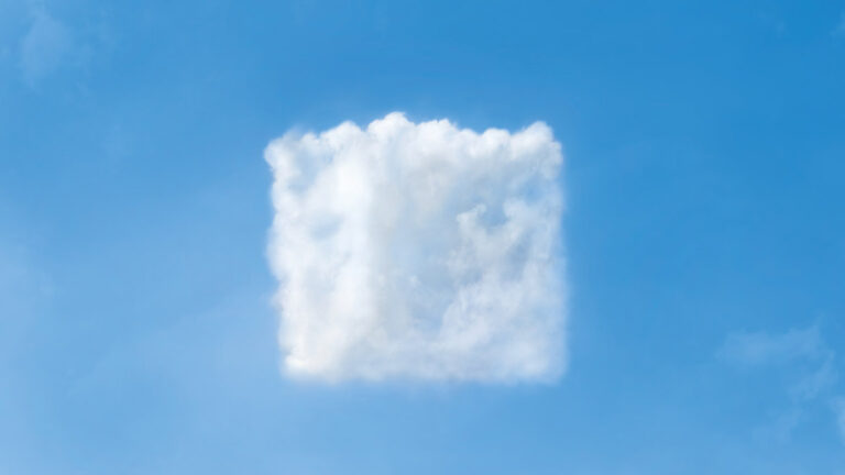 A single, fluffy, cube-shaped cloud floats against a clear blue sky, creating a surreal and whimsical atmosphere with its geometric form.