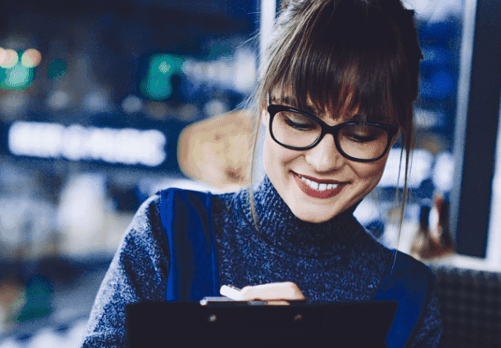 Woman writing on clipboard at desk