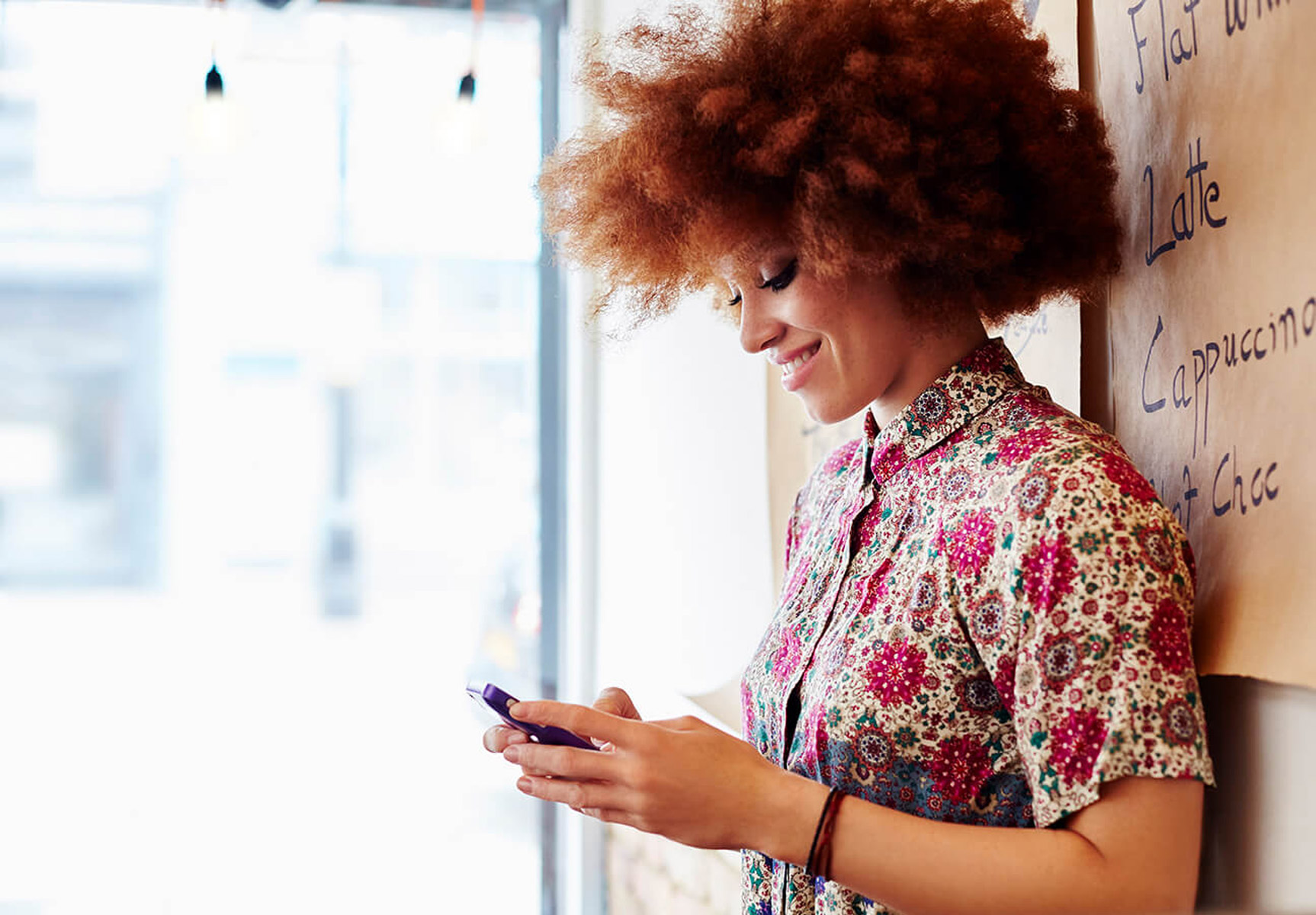 Woman on phone leaning against wall