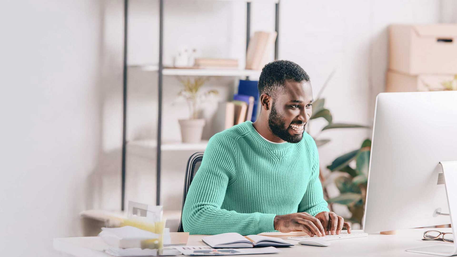 Man sitting at desk looking at desktop computer