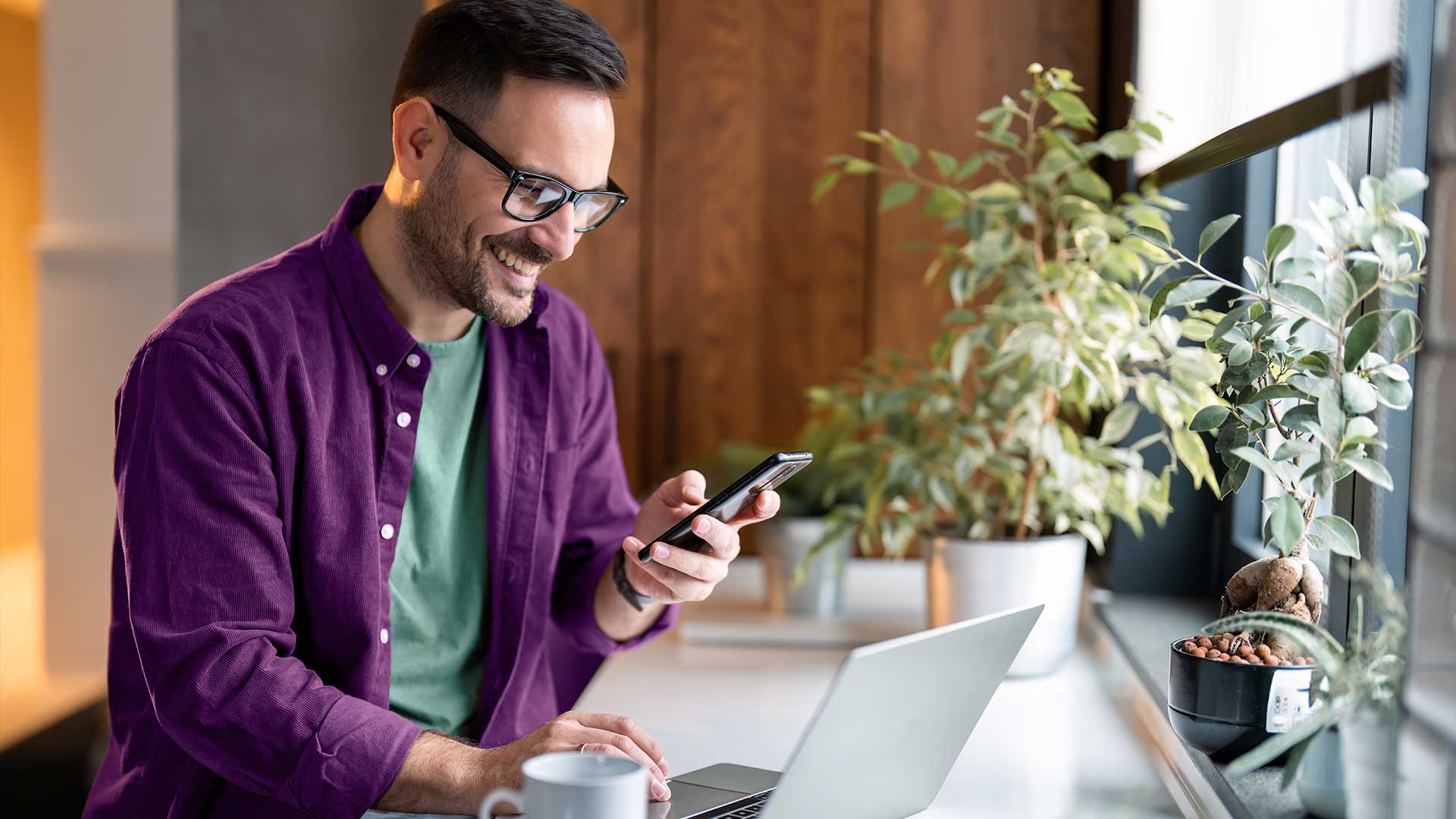 Man sitting in front of computer, on phone