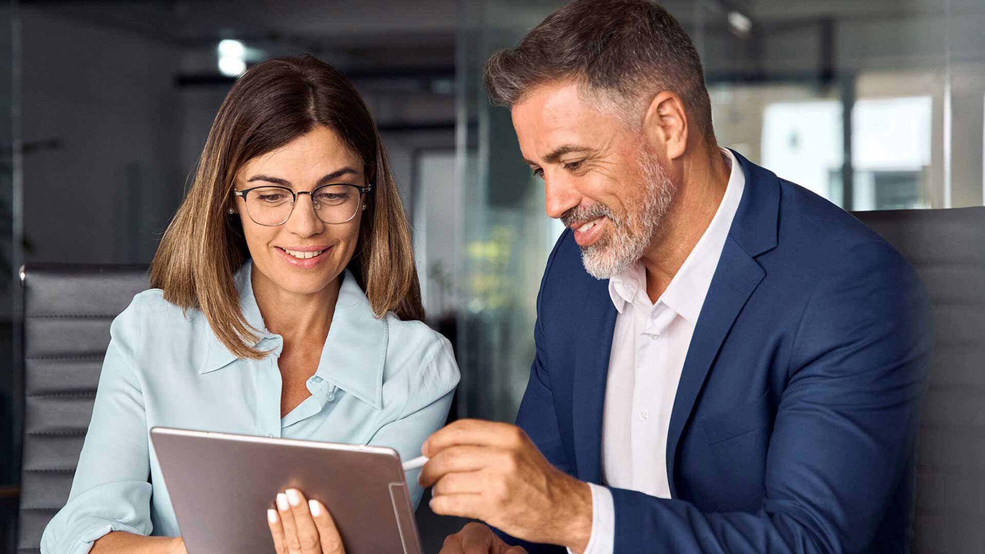Woman and man looking at a tablet working together