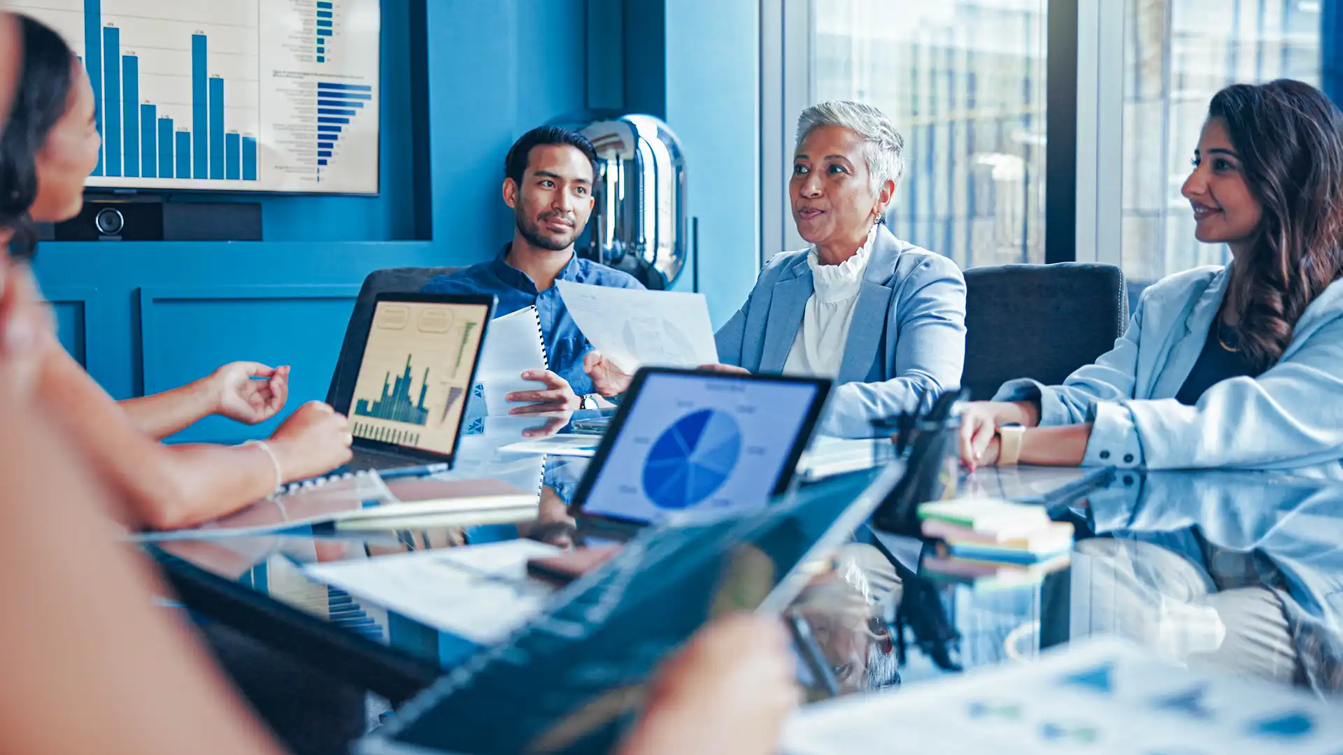 coworkers sitting around a conference room table, meeting