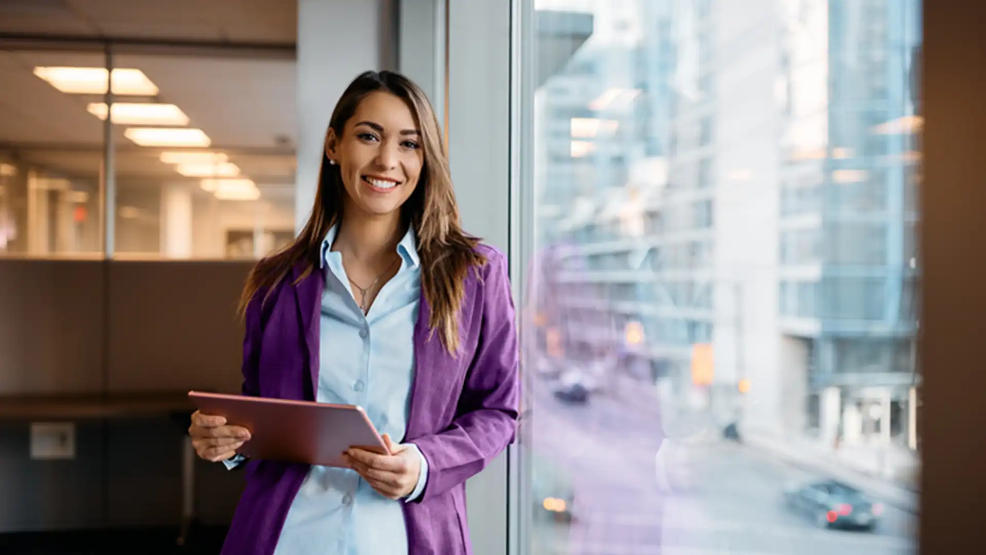 Woman standing by window holding tablet
